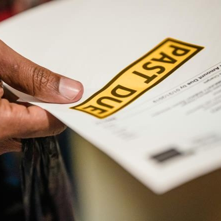 Person holding past due bill that has led to wage garnishment