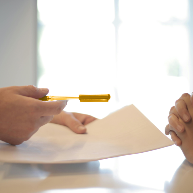 Une personne tend un stylo à quelqu'un qui fait face à une dette de prêt sur salaire