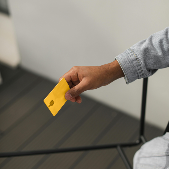 Personne détenant une carte jaune cherchant des solutions pour gérer un solde de carte de crédit qu'elle ne peut pas rembourser