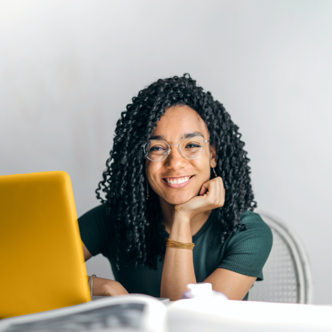 Étudiante assise à un bureau avec un ordinateur portable