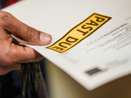 Person holding past due bill that has led to wage garnishment