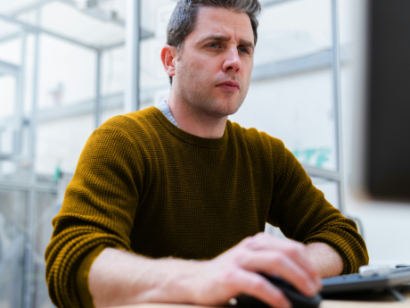 Man seated at computer contemplating using RRSP to pay off debt