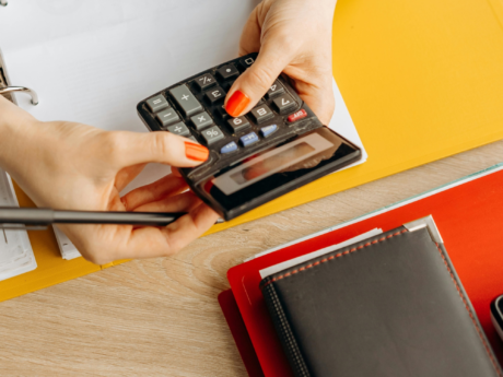 Personne tenant une calculatrice lors de la création d'un budget de base