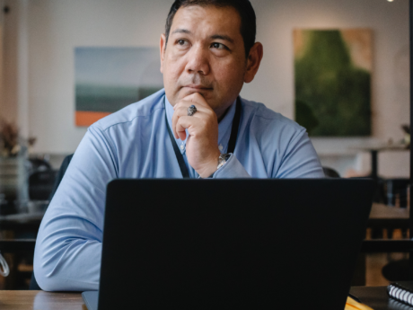 Man seated at a desk contemplating filing personal bankruptcy