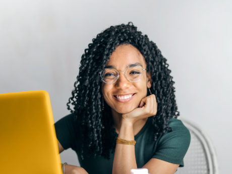 Étudiante assise à un bureau avec un ordinateur portable