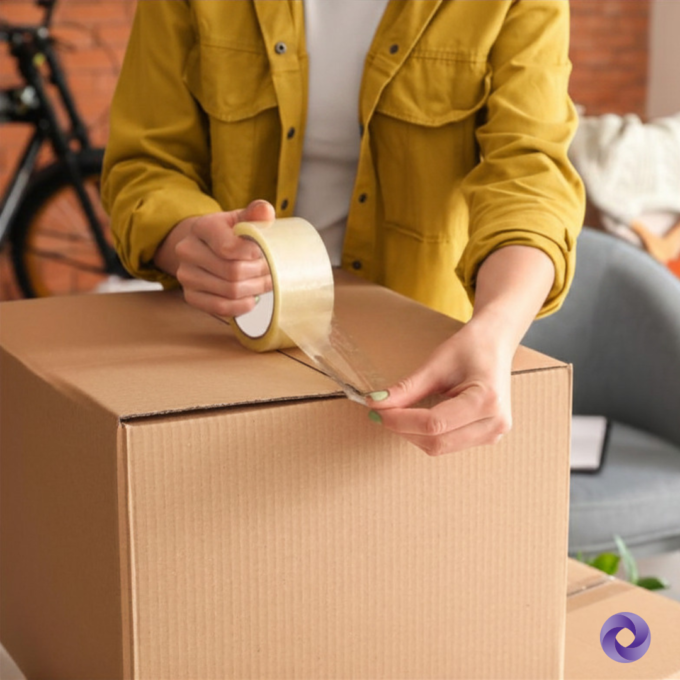 Person packing a box for moving